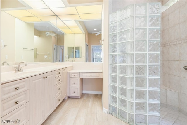 bathroom with ceiling fan, vanity, walk in shower, and hardwood / wood-style floors