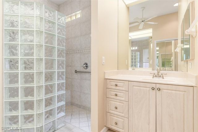 bathroom featuring tiled shower, ceiling fan, and vanity