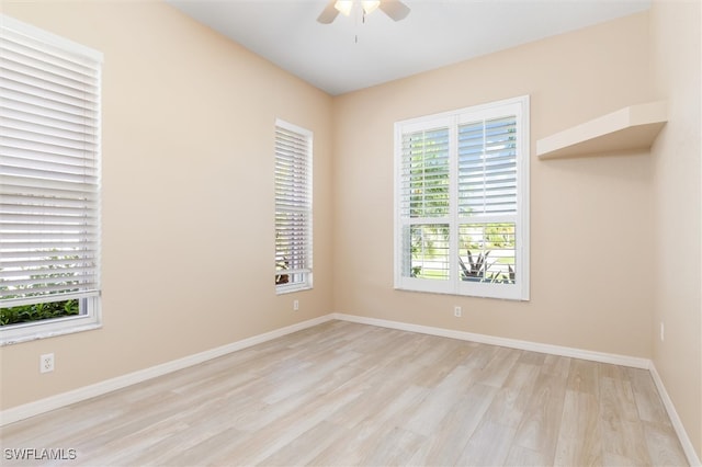 unfurnished room featuring a wealth of natural light, ceiling fan, and light wood-type flooring