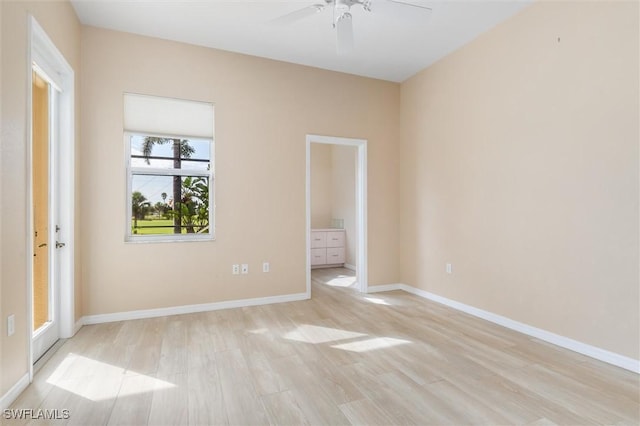 unfurnished room featuring light wood-type flooring, baseboards, and a ceiling fan