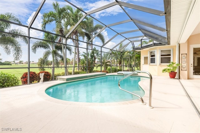 view of pool with glass enclosure and a patio area