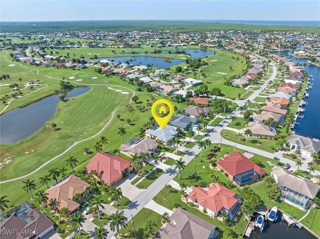 birds eye view of property with view of golf course, a water view, and a residential view