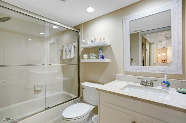 full bathroom with combined bath / shower with glass door, vanity, and toilet