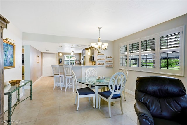 dining area featuring track lighting, light tile patterned floors, a wealth of natural light, and an inviting chandelier