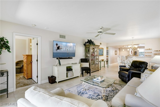 living room featuring ceiling fan with notable chandelier and light tile patterned floors