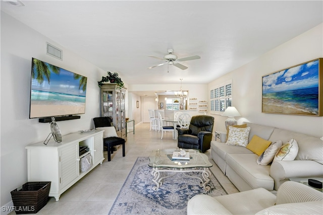 living room featuring light tile patterned floors and ceiling fan with notable chandelier