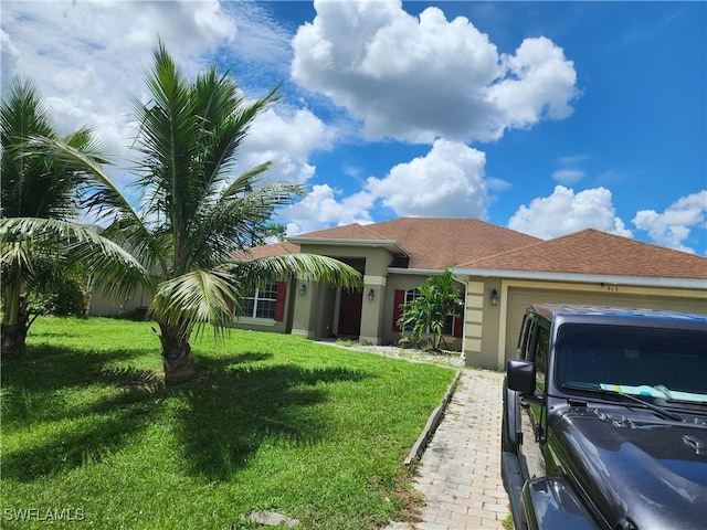 915 Alvin Ave, Lehigh Acres, FL 33971 - view of front of house featuring stucco siding, a front lawn, and an attached garage