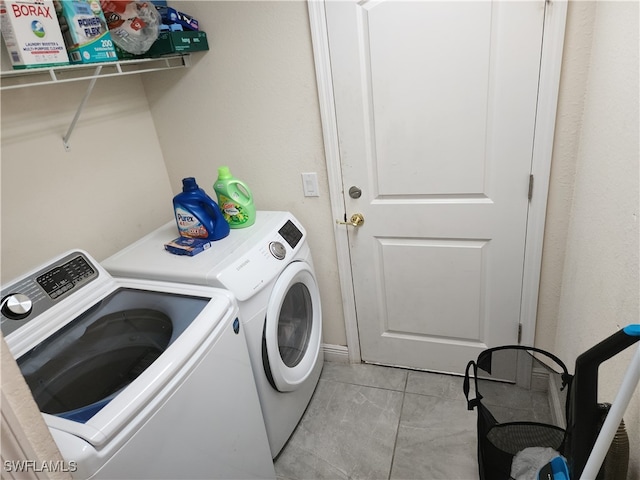 laundry area featuring light tile patterned floors and separate washer and dryer