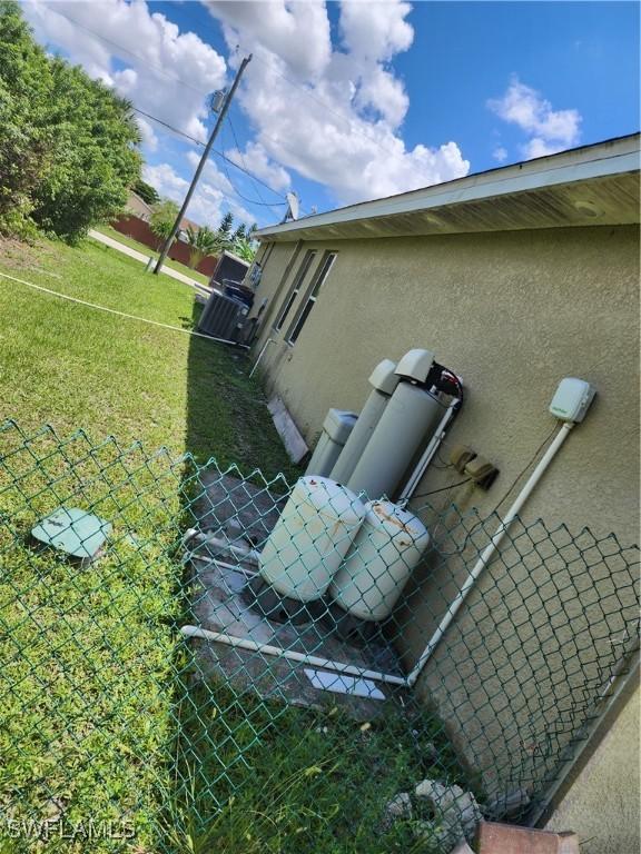 915 Alvin Ave, Lehigh Acres, FL 33971 - details featuring stucco siding and fence