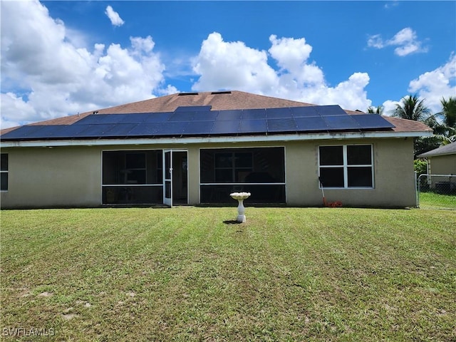 915 Alvin Ave, Lehigh Acres, FL 33971 - rear view of property with solar panels, a yard, a sunroom, and stucco siding