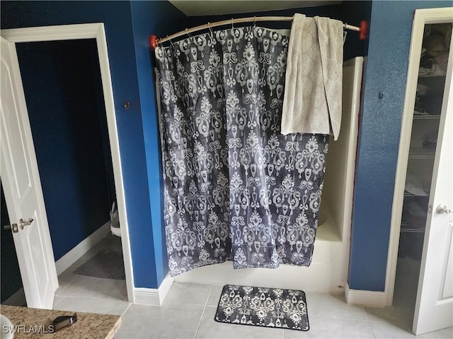 915 Alvin Ave, Lehigh Acres, FL 33971 - bathroom with tile patterned floors, a spacious closet, shower / tub combo, and baseboards