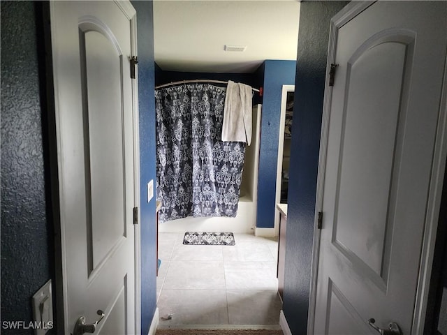 915 Alvin Ave, Lehigh Acres, FL 33971 - bathroom with tile patterned floors, shower / bathtub combination with curtain, and a textured wall
