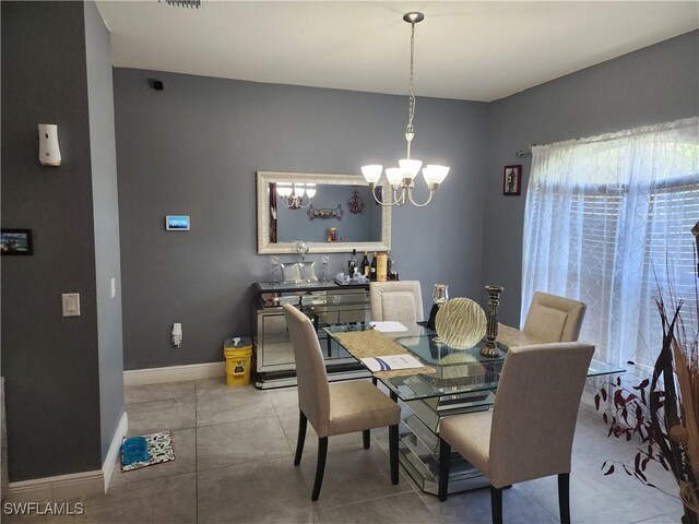 tiled dining room featuring an inviting chandelier