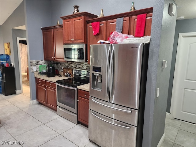 kitchen with light tile patterned floors, appliances with stainless steel finishes, backsplash, and lofted ceiling