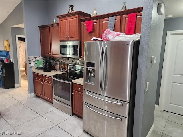 915 Alvin Ave, Lehigh Acres, FL 33971 - kitchen featuring light tile patterned floors, stainless steel appliances, baseboards, and decorative backsplash