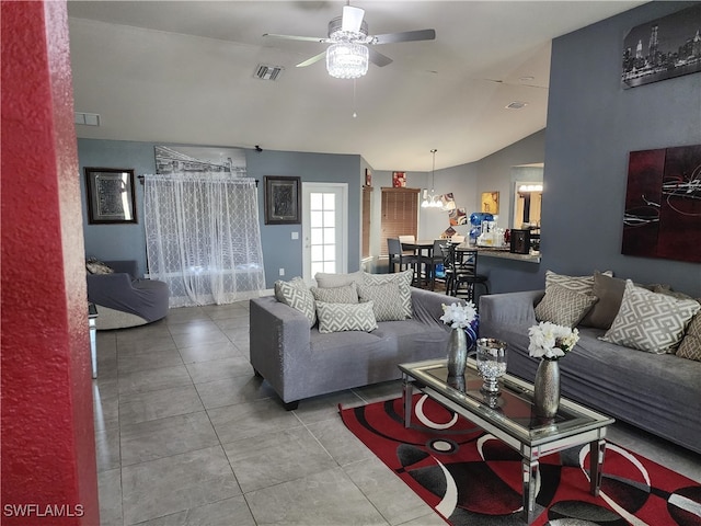 tiled living room with ceiling fan and vaulted ceiling