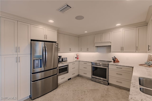 kitchen with white cabinets, appliances with stainless steel finishes, light stone countertops, and light tile patterned flooring