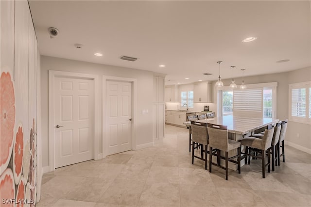 dining space featuring sink and light tile patterned floors