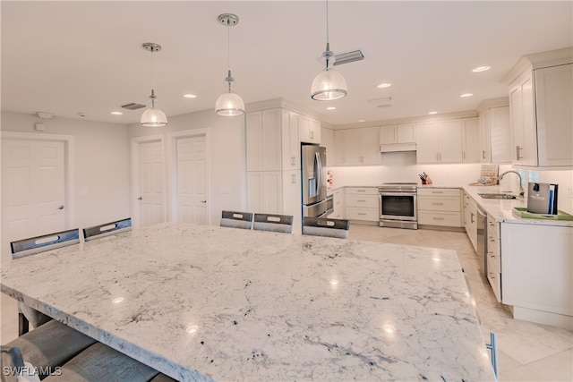 kitchen featuring appliances with stainless steel finishes, a breakfast bar area, and white cabinetry