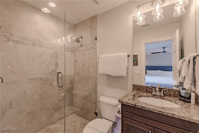 bathroom featuring toilet, ceiling fan, a shower with door, and vanity