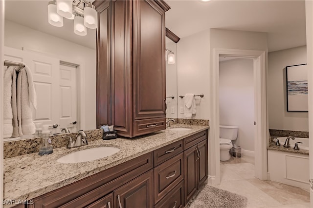 bathroom with vanity, toilet, tile patterned floors, and a washtub