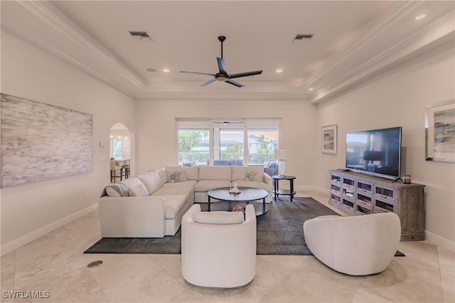 living room featuring a raised ceiling, ceiling fan, and light tile patterned flooring