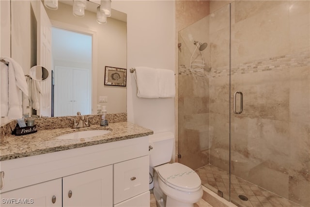 bathroom with toilet, an enclosed shower, and vanity