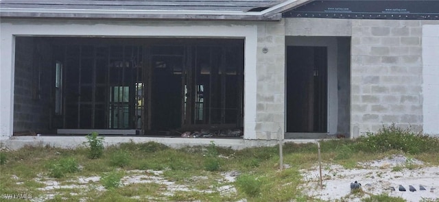 view of exterior entry featuring roof with shingles