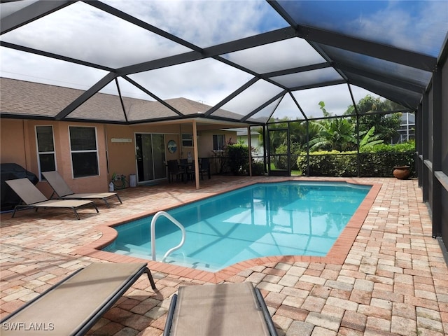 view of swimming pool with glass enclosure and a patio