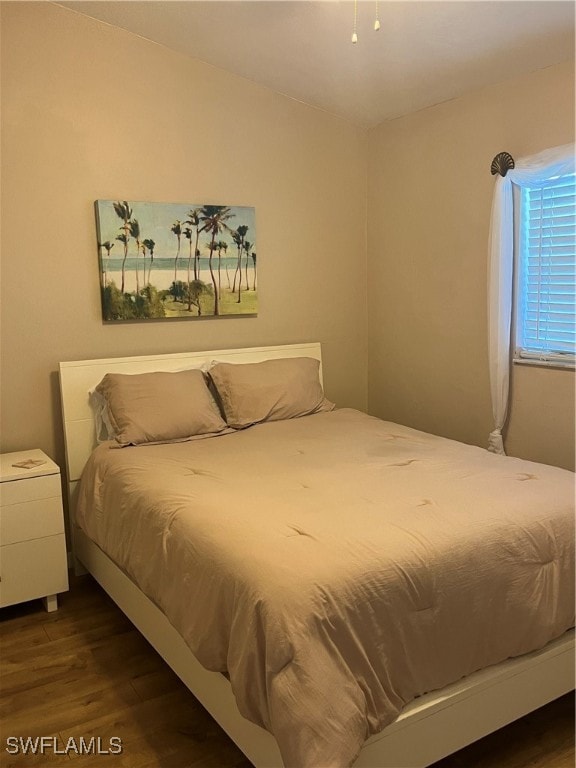 bedroom with dark hardwood / wood-style floors