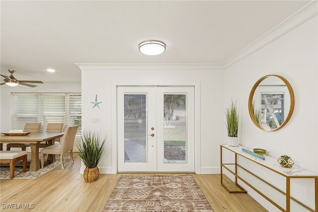 foyer featuring plenty of natural light, french doors, light hardwood / wood-style floors, and ornamental molding