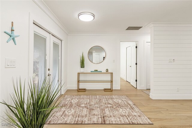 hallway featuring light wood-type flooring and crown molding