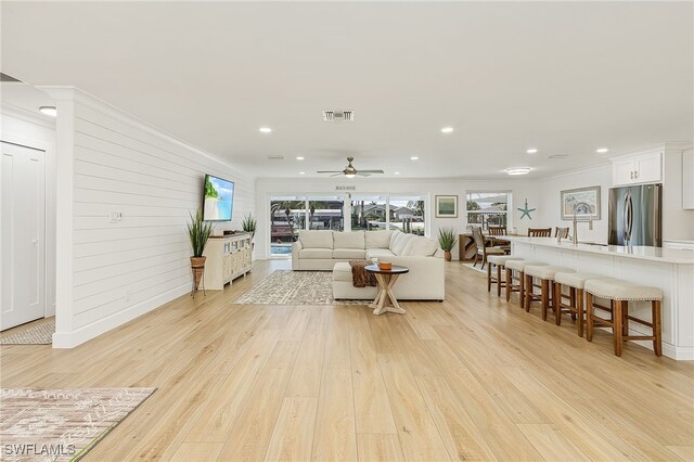 living room with light wood-type flooring and ceiling fan