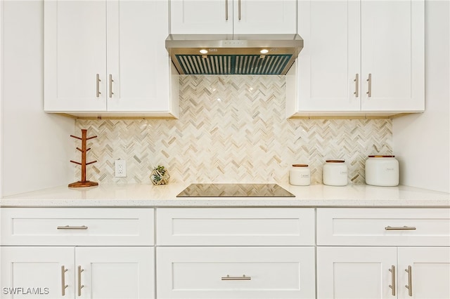 kitchen with decorative backsplash, wall chimney range hood, and white cabinets