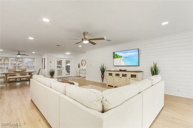 living room featuring ceiling fan, light hardwood / wood-style floors, and french doors