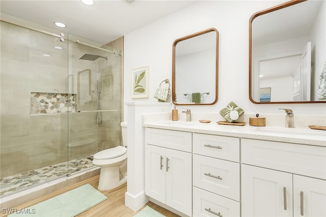 bathroom with a shower with door, toilet, hardwood / wood-style floors, and vanity