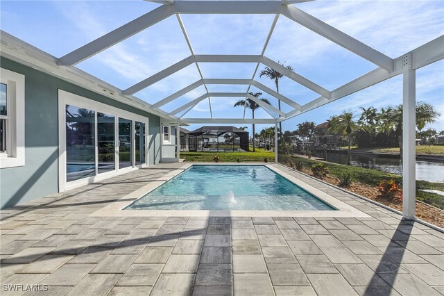 view of swimming pool featuring glass enclosure, a patio area, a water view, and pool water feature