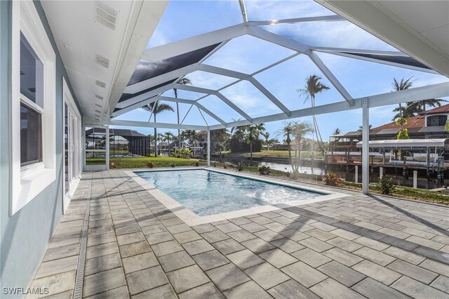 view of swimming pool with a patio, a water view, and a lanai