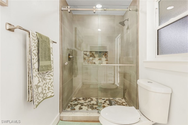 full bath featuring a stall shower and toilet