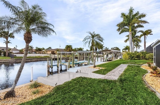 view of dock featuring a lawn, a water view, and boat lift