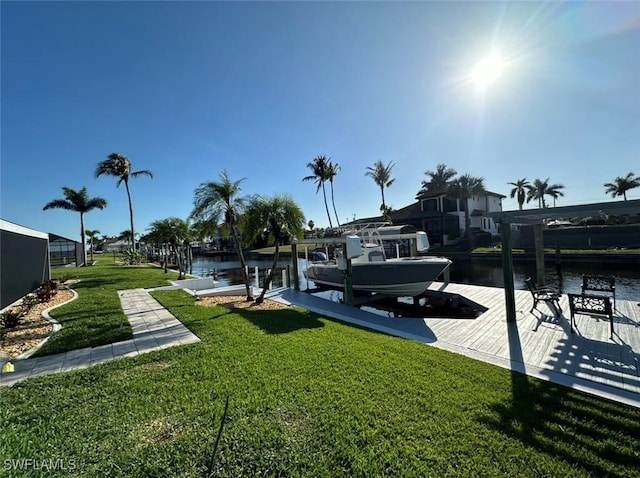 view of dock with a water view, a yard, and boat lift