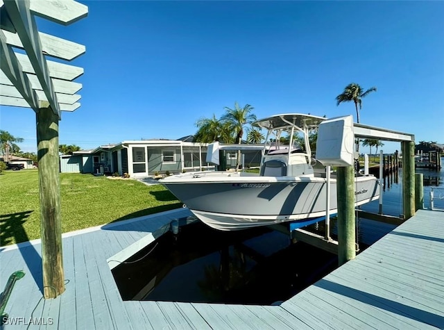 view of dock with a lawn and boat lift