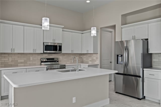 kitchen with a kitchen island with sink, sink, stainless steel appliances, and tasteful backsplash