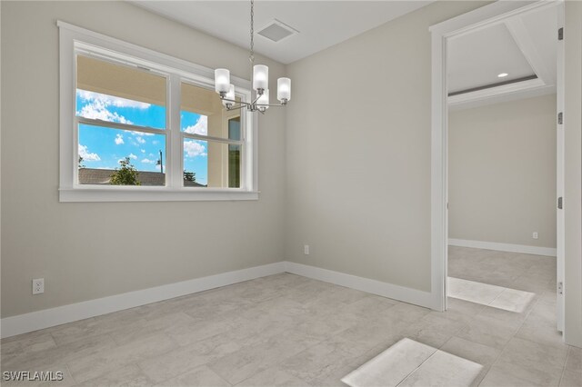 spare room with light tile patterned flooring, a notable chandelier, and a tray ceiling