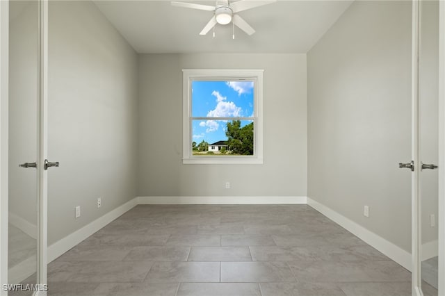 tiled empty room with ceiling fan and french doors