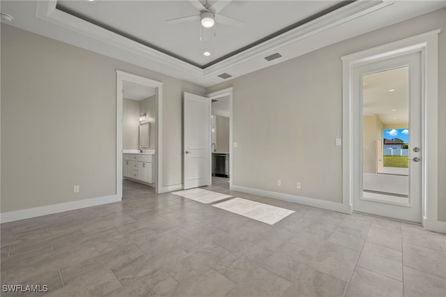 unfurnished bedroom featuring a tray ceiling, ceiling fan, light tile patterned flooring, and ensuite bathroom