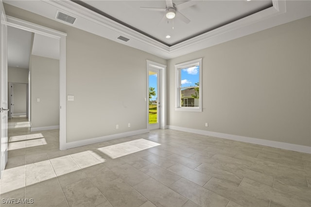 tiled empty room featuring ceiling fan and a raised ceiling