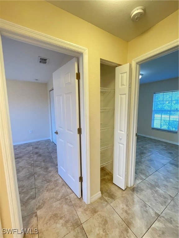 corridor with light tile patterned flooring