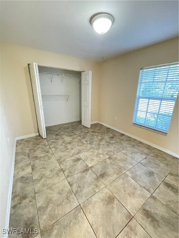 unfurnished bedroom with a closet and light tile patterned floors