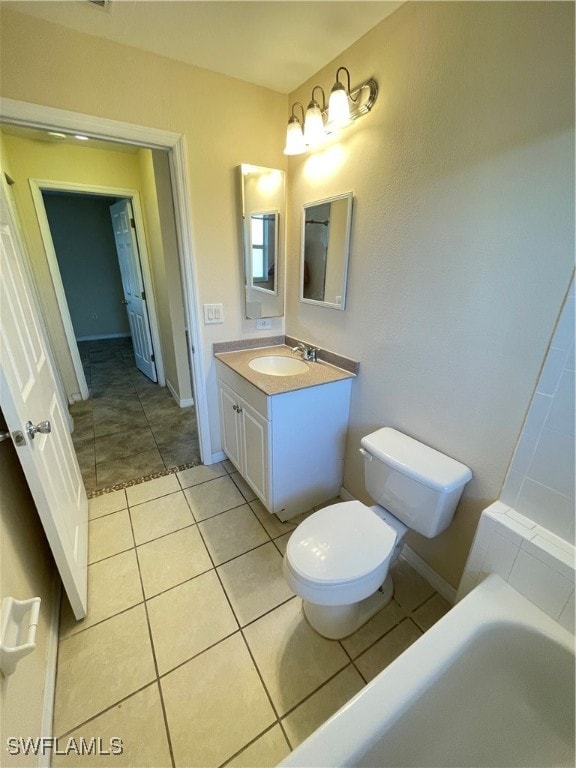 bathroom featuring tile patterned flooring, toilet, a bathing tub, and vanity